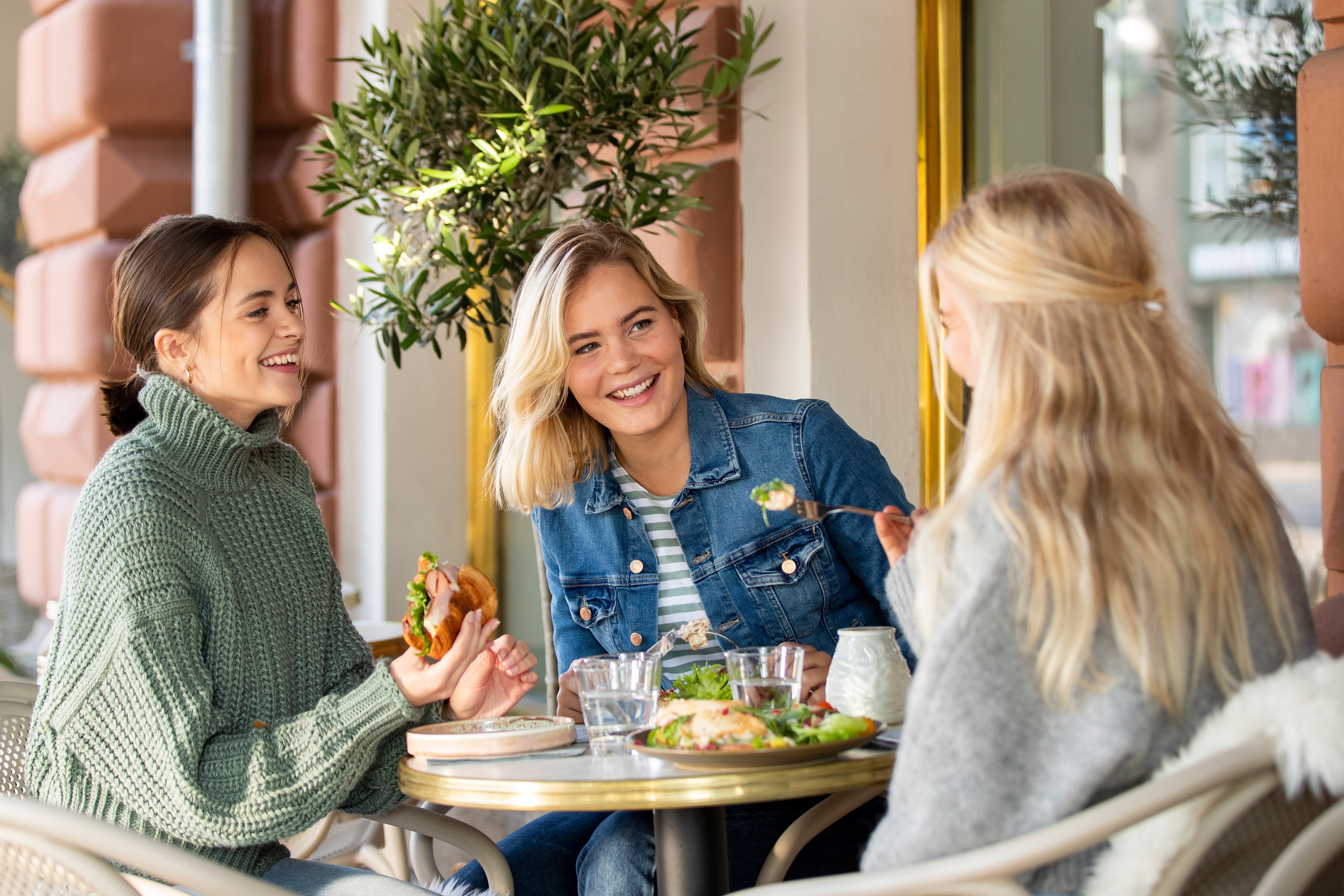 Unga kvinnor äter lunch tillsammans - mångsidiga matlösningar